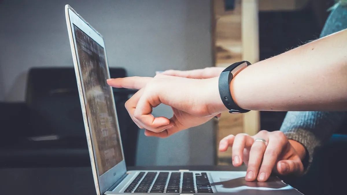 Someone pointing at a laptop while sending a document request