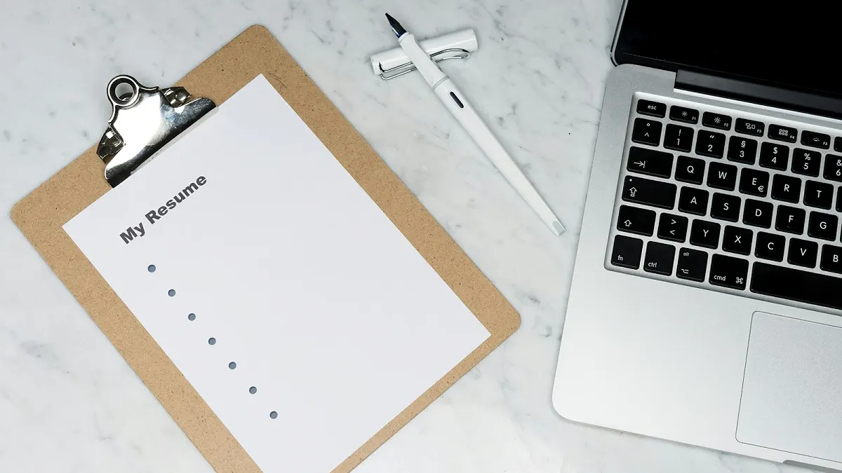 A document ready for review beside a laptop